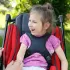 Fröhliches Mädchen sitzt sicher und bequem im EASyS Advantage Reha-Kinderwagen mit gepolstertem Sitz.